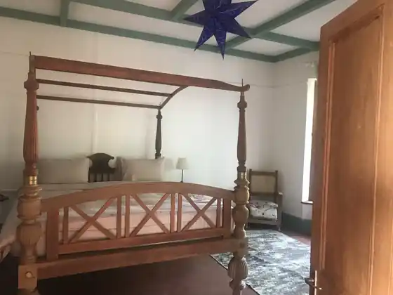 The bungalow's second en-suite bedroom with a carved four-poster bed