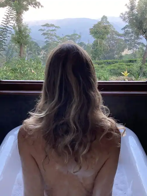 A guest gazing out at the hills from the bungalow
