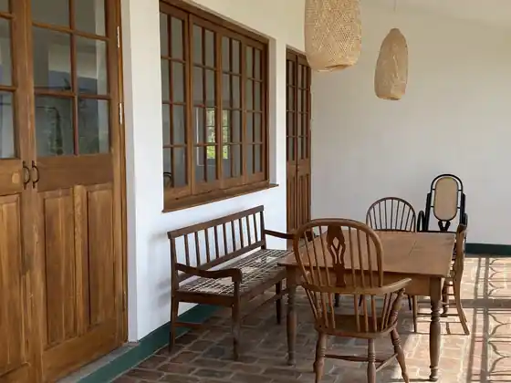 Wooden bench, chairs and hanging lamps on the Library Suite veranda