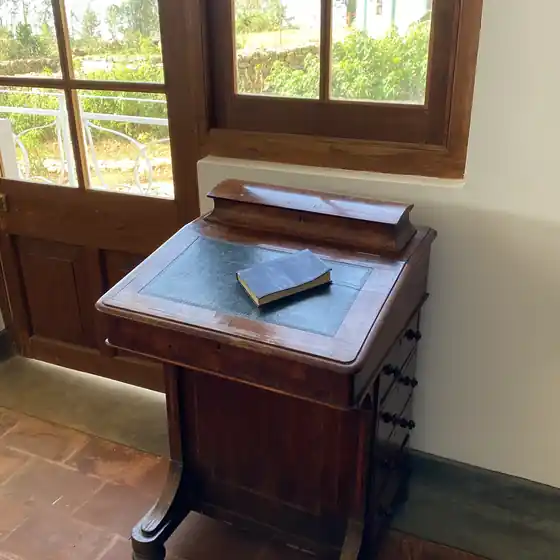 An antique writing slope on a desk by the window in the Library Suite